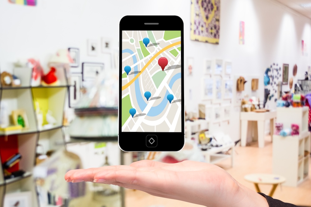 Hand with iPhone and map showing local search